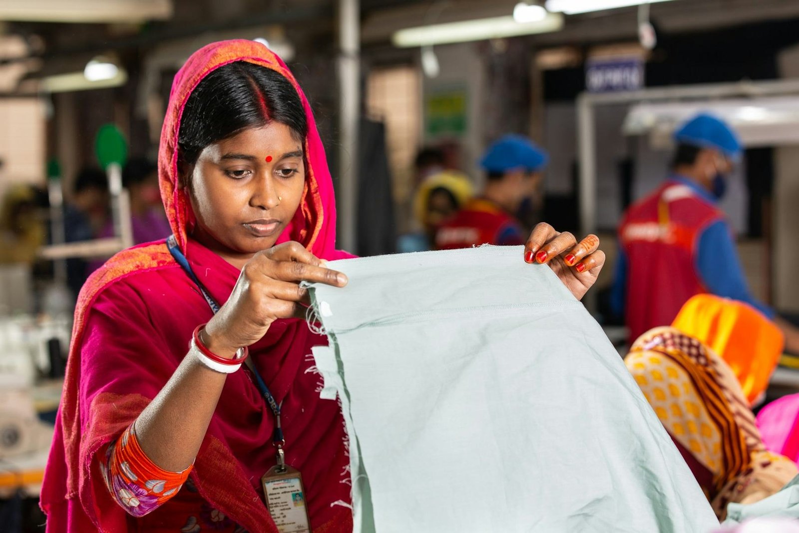 A quality controller inspecting a finished garment on the factory floor